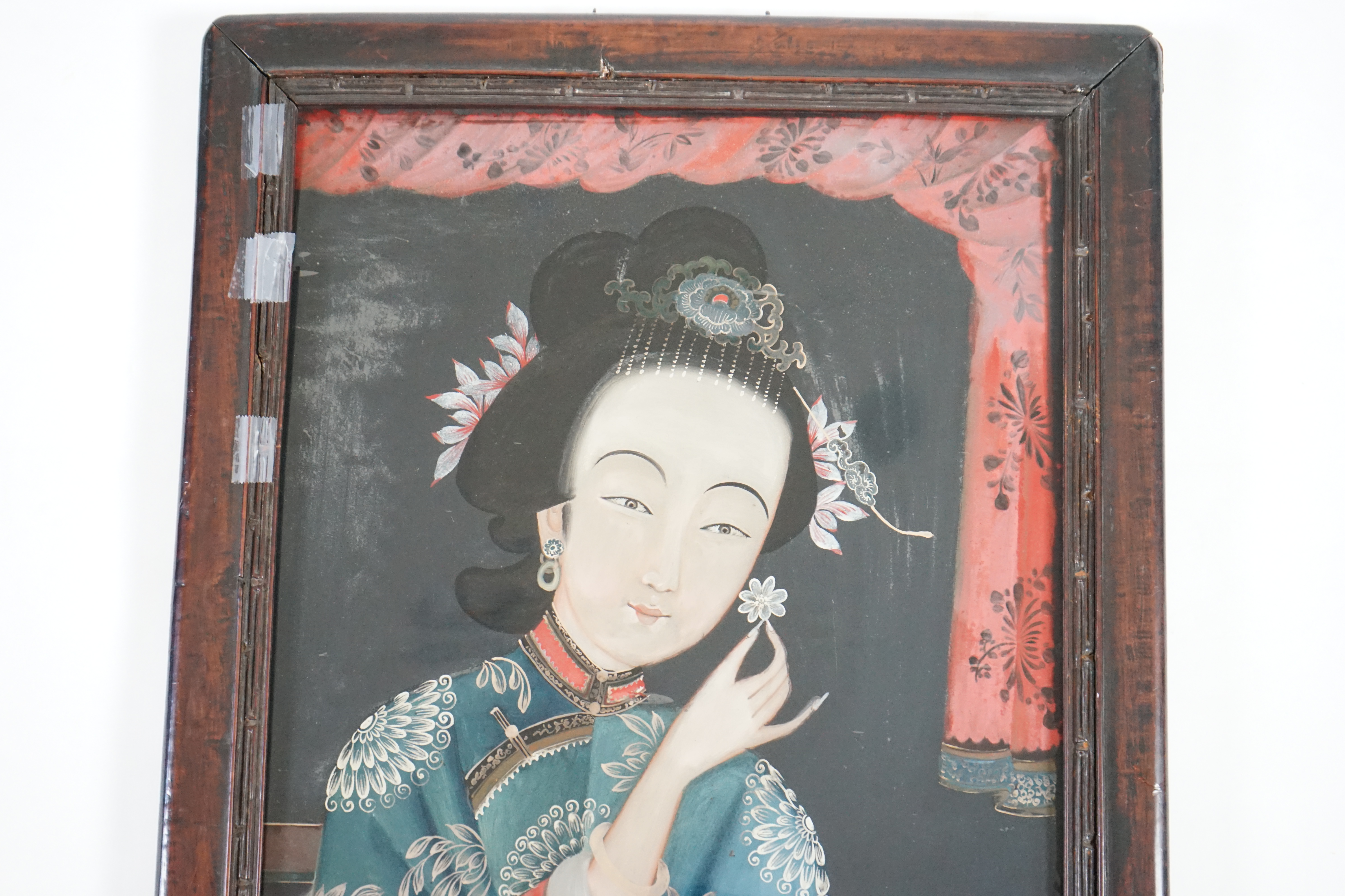 A Chinese reverse painting on glass of a lady holding a flower, 19th century